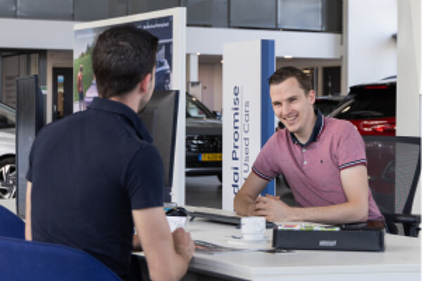 Autoverkoper in gesprek met klant