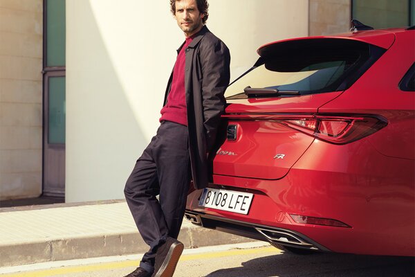 man-leaning-on-the-back-of-the-car-new-seat-leon- desire-red-colour.jpg