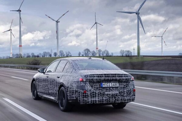 bmw-i5-achterkant-camouflage-driving-shot-windmolens