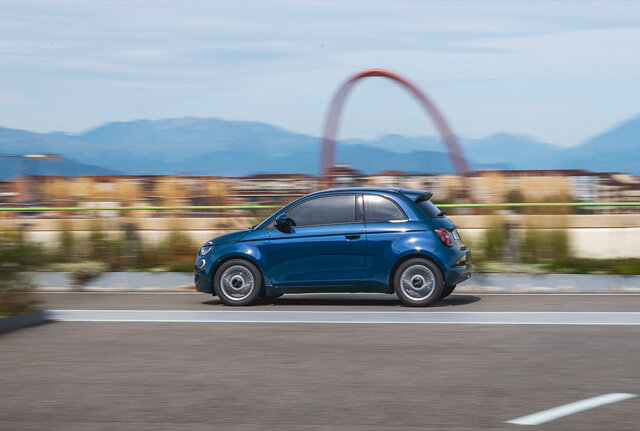 Een nieuwe blauwe Fiat 500 Hybrid 2025 rijdend over het dak van de Fiatfabriek in Turijn