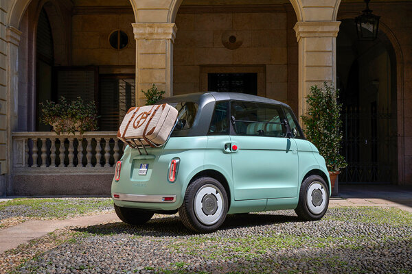 Achterkant van de Topolino met deurtjes, bagagerekje en een koffer op Italiaans pleintje.