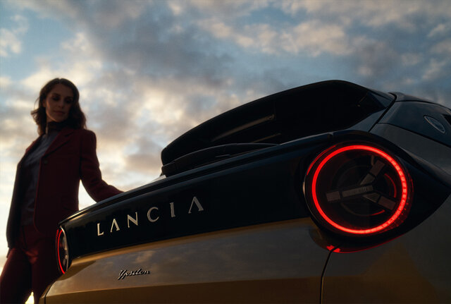 Vrouw leunt op de achterkant van de Lancia Ypsilon Electric